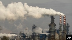 FILE - In this Nov. 28, 2019, file photo, smoke and steam rise from a coal processing plant in Hejin in central China's Shanxi Province. 