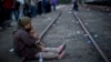 An Afghan refugee woman holding her daughter rests while waiting to board a train heading to the Austrian border, in Roszke, southern Hungary, Sept. 14, 2015. 