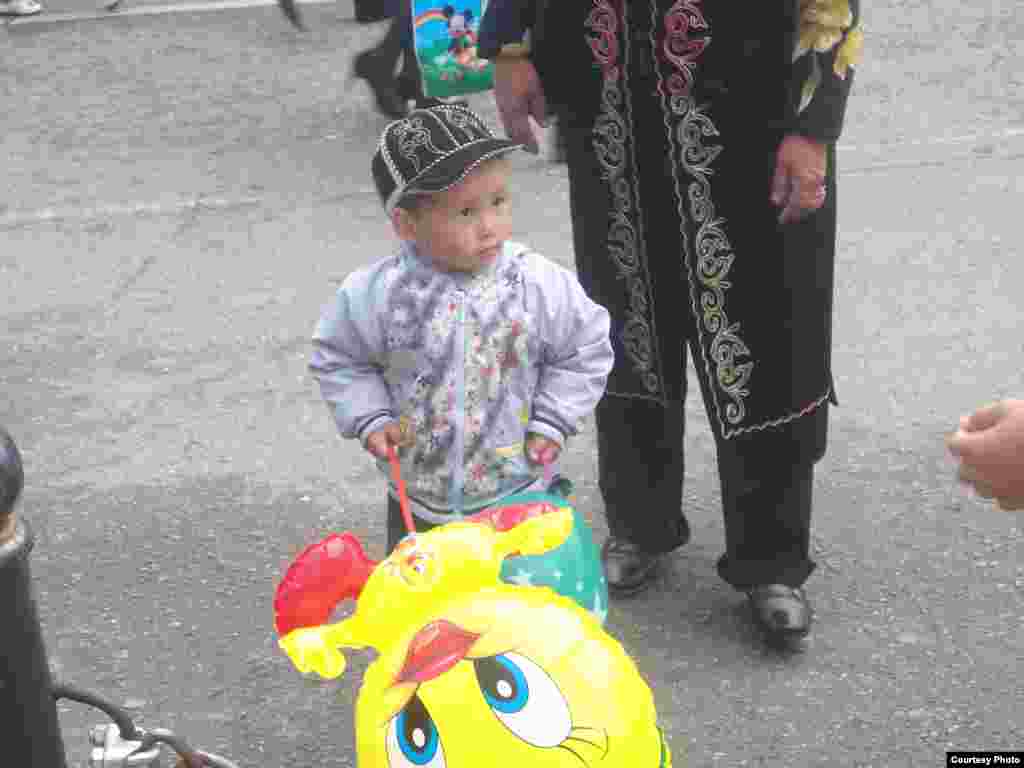 Yosh bolakay qo'lida shishirilgan o'yinchoq bilan