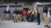 Policemen and rescue workers gather outside a building where unidentified gunmen killed police cadets in Lahore on July 12, 2012. 