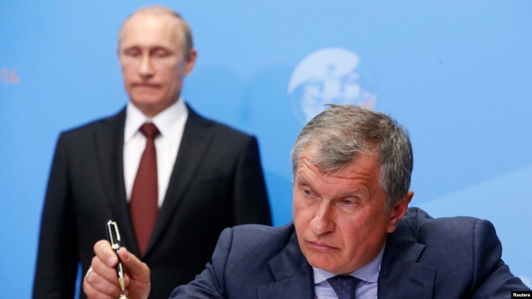 Russia's President Vladimir Putin (back) and Rosneft CEO Igor Sechin attend a signing ceremony at the St. Petersburg International Economic Forum 2014 in St. Petersburg, May 24, 2014.
