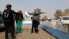 A police officer searches a man at a check point, as security increases after a bomb attack, at Abu Ghraib district, west of Baghdad, Jan. 9, 2014. 