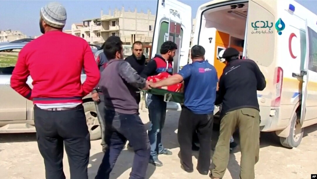 FILE - An injured person is carried on stretcher into an ambulance after an airstrike on location targeted by government and aliied forces, in Khan Sheikhoun, Idlib, Syria, Feb. 26, 2019,