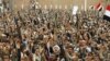 File - Shi'ite Muslim rebels hold up their weapons during a rally against air strikes in Sanaa, Yemen, March 2015.