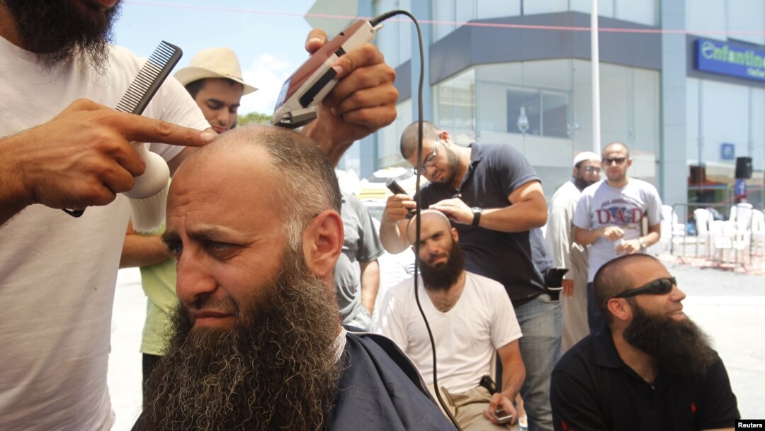 Ahmad Assir (L) and his supporters shave their heads during the sit-in in Sidon July 4, 2012.