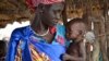 FILE - Elizabeth Nyakoda holds her severely malnourished 10-month old daughter at the feeding center for children in Jiech, Ayod County, South Sudan, Dec. 10, 2017. 