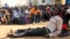 FILE - Illegal immigrants who were abandoned by traffickers in a remote desert area wait inside a military base in Dongola town, after being located by Sudanese and Libyan forces, May 3, 2014. 