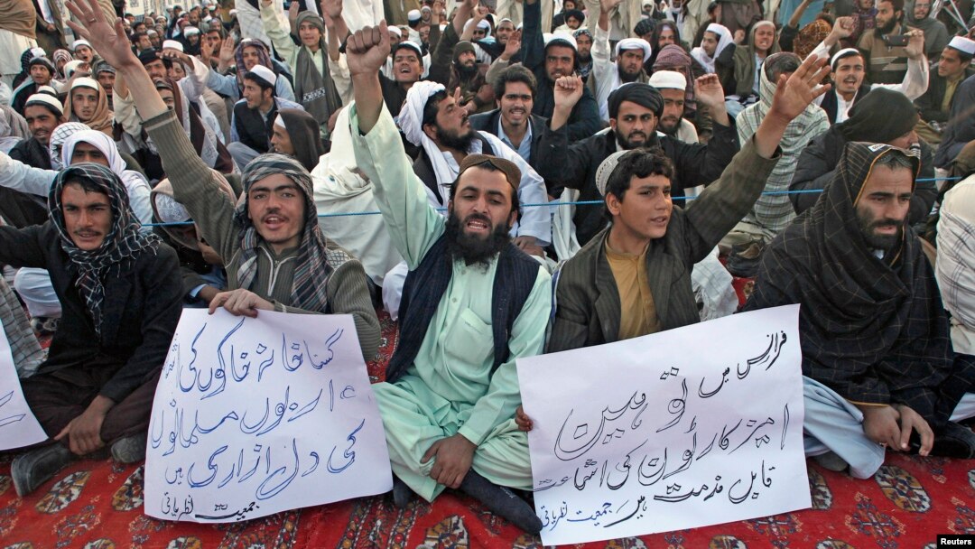 People hold signs as they chant slogans during a protest against satirical French weekly newspaper Charlie Hebdo, in Quetta, Pakistan, Jan. 15, 2015.