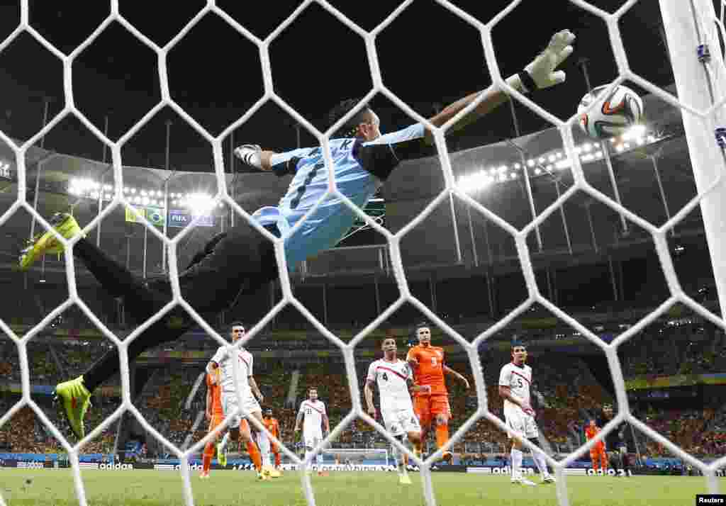Kosta Rika darvozaboni Keylor Navas Niderlandiya hujumchisi Vesli Sneyder tepgan jarima to&#39;pini qaytarmoqda, 5-iyul, 2014-yil.