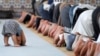 FILE - A child is seen near members of the Muslim community attending midday prayers at Strasbourg Grand Mosque in Strasbourg, France, on the first day of Ramadan.