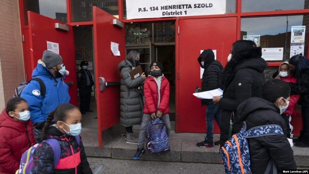 Students arrive at P.S. 134 Henrietta Szold Elementary School, Monday, Dec. 7, 2020, in New York. Public schools reopened for in-school learning Monday after being closed since mid-November. (AP Photo/Mark Lennihan)
