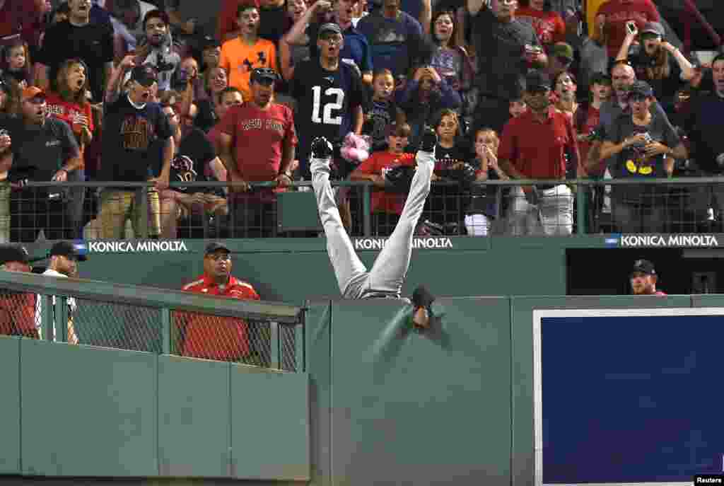 Cleveland Indians center fielder Austin Jackson (26) falls over the wall after making a catch to rob Boston Red Sox designated hitter Hanley Ramirez (not pictured) of a home run during the fifth inning at Fenway Park in Boston, Massechusetts. (Credit: Bob DeChiara/USA TODAY Sports)