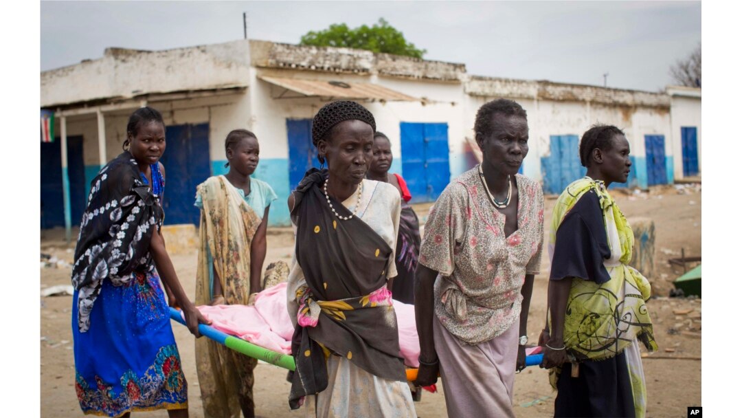 Women carry the body of a civilian killed in the center of Malakal, Upper Nile State in South Sudan, Jan. 21, 2014.