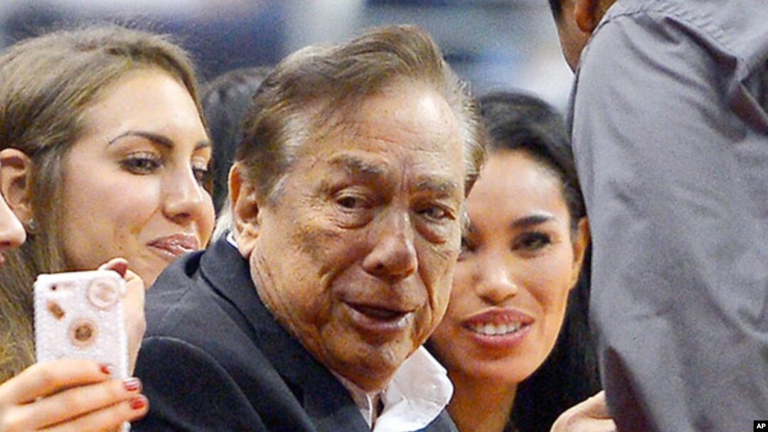 FILE - Los Angeles Clippers owner Donald Sterling, center, and V. Stiviano, right, watch the Clippers play the Sacramento Kings.