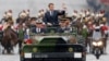 New French President Emmanuel Macron waves from a military vehicle as he rides on the Champs Elysees avenue towards the Arc de Triomphe in Paris, May 14, 2017. 