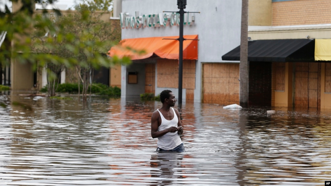 John Duke wades through a flooded street to try to salvage his flooded car in the wake Hurricane Irma, Sept. 11, 2017, in Jacksonville, Fla.