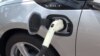 In this image taken from video, an electric vehicle is plugged into a charger, March 2017.