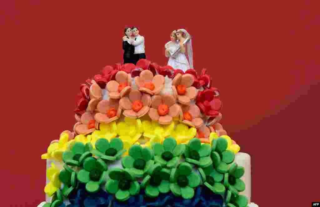 A wedding cake in rainbow colors and decorated with figurines of two women and two men is pictured in Berlin. The German parliament legalized same-sex marriage, days after Chancellor Angela Merkel said she would allow her conservative lawmakers to follow their conscience in the vote.