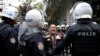 FILE - A woman argues with riot police as they detain protesters during a demonstration against the arrest of Nuriye Gulmen and Semih Ozakca, who are on hunger strike protest, in Ankara, Turkey, May 22, 2017.