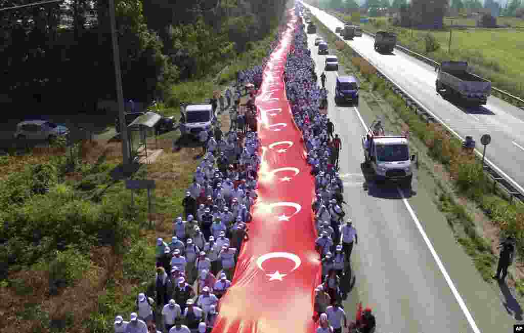 Thousands of supporters hold a 1,100 meter-long national flag as they follow Kemal Kilicdaroglu, the leader of Turkey's main opposition Republican People's Party, on the 17th day of his 425-kilometer (265-mile) march in Sakarya, some 220 kilometers from the capital Ankara.