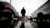 FILE - An Immigration and Customs Enforcement agent watches cars as they wait to enter the United States from Tijuana, Mexico, through the San Ysidro port of entry in San Diego, Dec. 3, 2014..