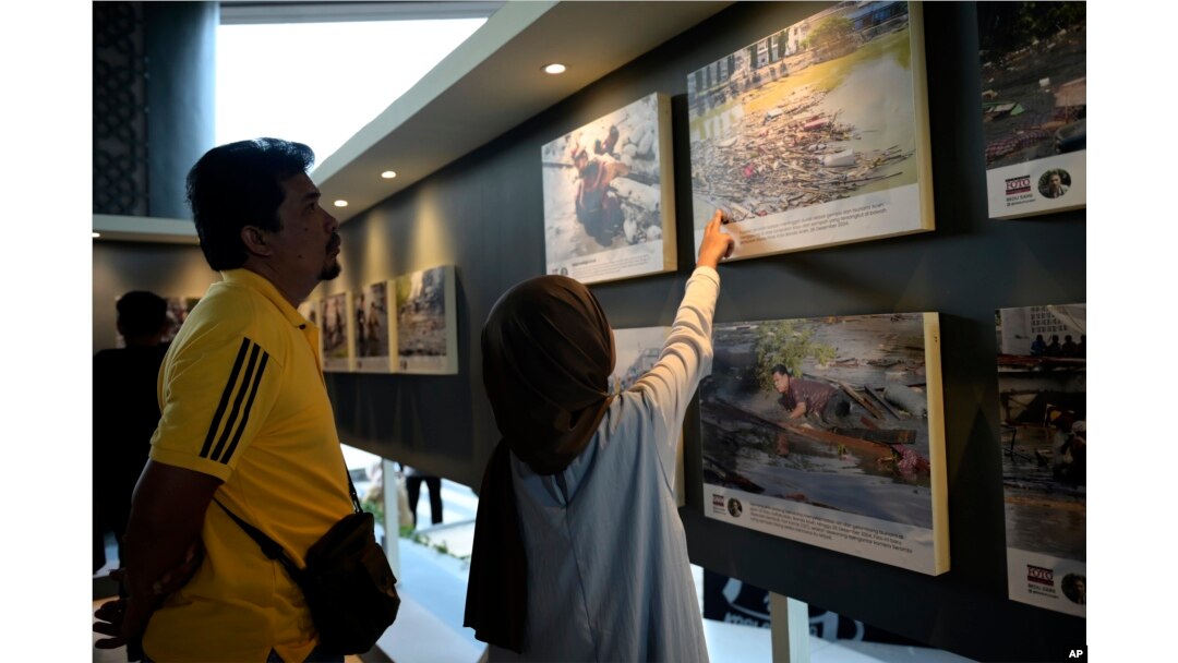 People look at photos of the Indian Ocean tsunami during the commemoration of the 20th anniversary of the disaster, in Banda Aceh, Indonesia, Dec. 26, 2024.
