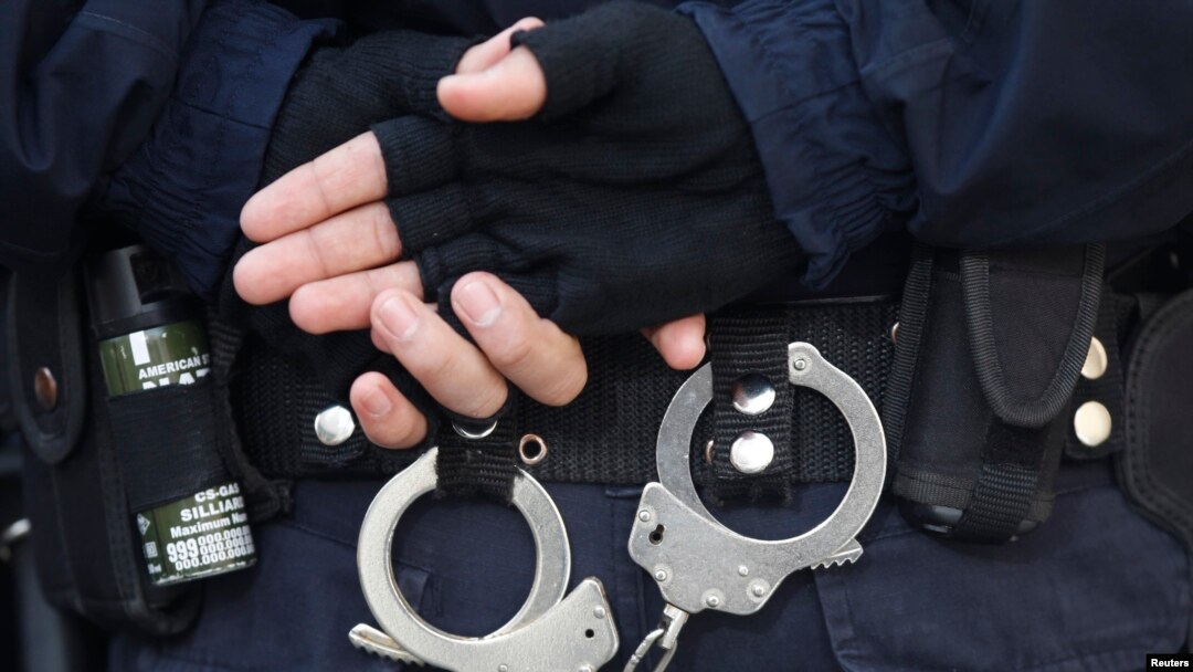 FILE - A Turkish riot police officer's handcuffs are pictured at the entrance of a courthouse in Istanbul. 
