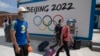 2022年冬季奥运会一年后将在北京举行，目前，超过180个机构呼吁各国政府抵制这场赛事。图为到河北省张家口崇礼的游客走过北京2022冬季奥运会的广告牌。（美联社2020年8月13日资料照）