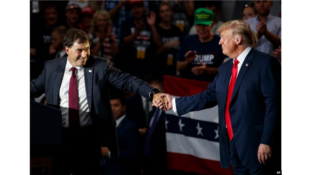 12th Congressional District Republican candidate Troy Balderson (L) reaches for President Donald Trump as he speaks at a rally at Olentangy Orange High School in Lewis Center, Ohio, Aug. 4, 2018.