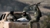 Anti-government fighters ride in the back of a pickup in the town of Suran, between Aleppo and Hama, Dec. 3, 2024.