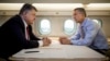 Ukrainian President Petro Poroshenko, left, and NATO Secretary General Jens Stoltenberg talk in a helicopter on the way to a military training ground outside Lviv, western Ukraine, Sept. 21, 2015. 