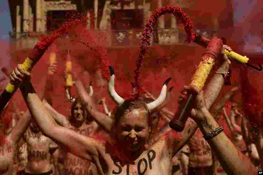 Demonstrators brake ''banderillas'' with red dust during a protest against bullfighting in front of the City Hall a day before of the San Fermin festival, in Pamplona, northern Spain.