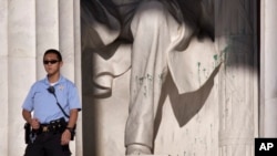 A U.S. Park Police officer stands guard next to the statue of Abraham Lincoln at the memorial in Washington, July 26, 2013