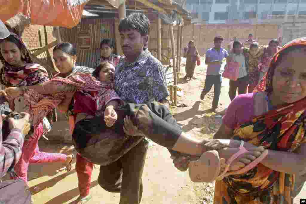 Garment workers assist injured colleagues during a clash with police in Ashulia on the outskirts of Dhaka, Bangladesh, Nov. 12, 2013.
