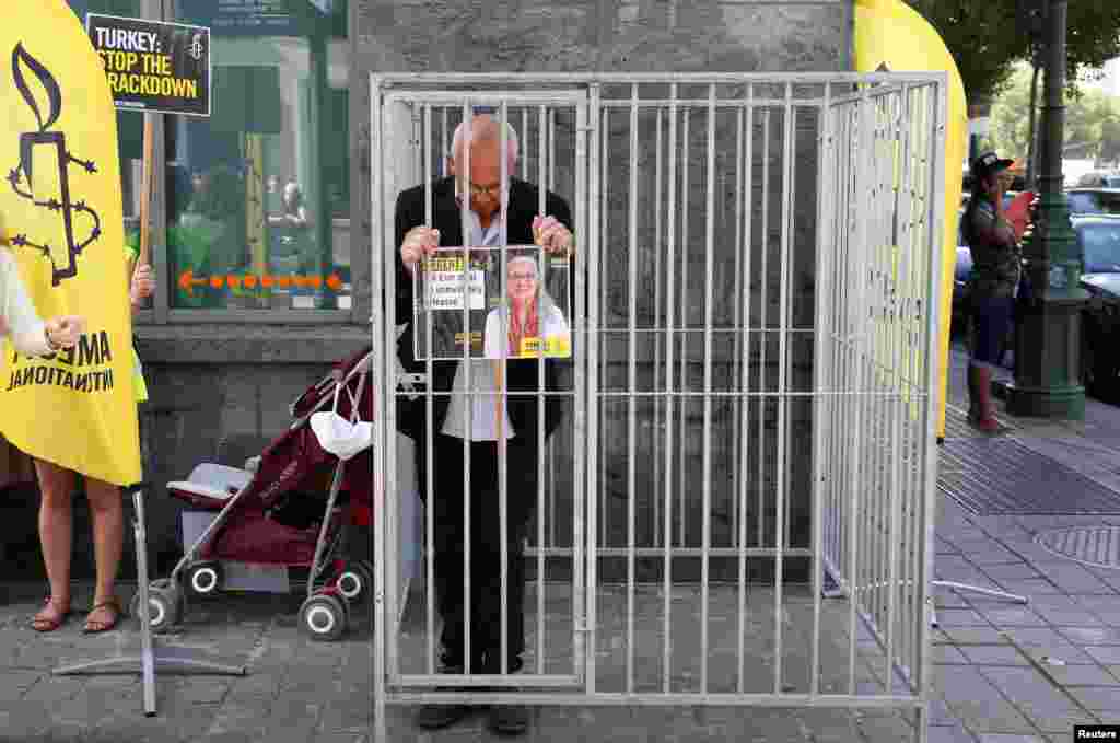 Amnesty International Belgium's Director Philippe Hensmans stands in a cage in front of the Turkish embassy in Brussels to protest against the detention of his Turkish counterpart Idil Eser.