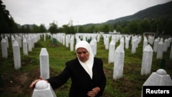 Mejra Dzogaz touches the graves of her two sons on May 17, 2012. Mejra's husband, three sons and a grandson were killed during the Srebrenica massacre in 1995 by a Serbian army unit commanded. 