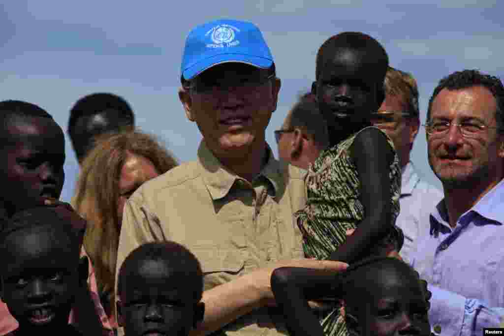 BMT Bosh kotibi Pan Gi-Mun Janubiy Sudanda ixtiloflar bois o'z uyini tark etgan qochoqlar uchun tashkil qilingan lagerda yosh bolani ko'tarib turibdi, Juba, 6-may, 2014-yil.