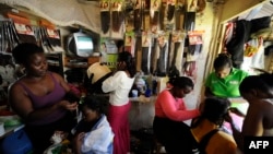 FILE - Kenyan hairdressers attend to clients at a salon in the capital Nairobi, Kenya.