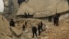 Civil defense members and other people inspect a damaged mosque after an airstrike on the village of al-Jinah, Aleppo province, in northwest Syria, March 17, 2017.