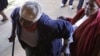 FILE - An elderly voter struggles into a polling station in Soweto, South Africa, May 2011.
