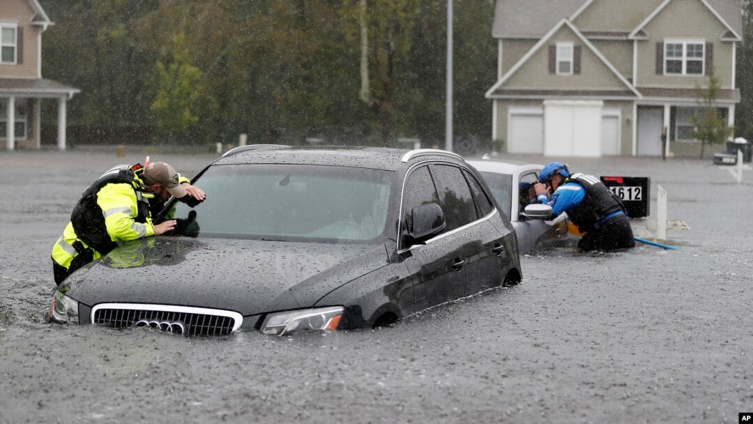 Members of the North Carolina Task Force urban search and rescue team check cars in a flooded neighborhood looking for residents who stayed behind as Florence continues to dump heavy rain in Fayetteville, N.C., Sunday, Sept. 16, 2018.