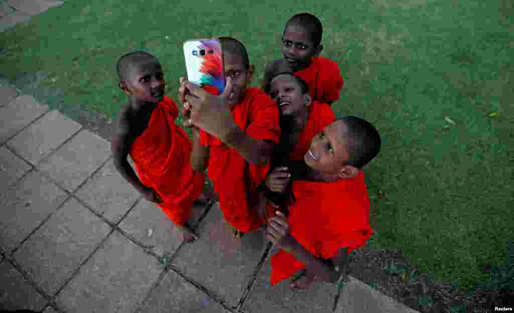 A group of novice Buddhist monks take selfies at a temple in Colombo, Sri Lanka, June 28, 2017.