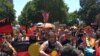 FILE - People carry Australian Aboriginal flags during a demonstration on Australia Day in Sydney, Jan. 26, 2019.