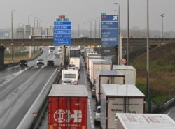FILE - Trucks bound for Britain wait on the access ramp to the Channel Tunnel in Calais, northern France, before leaving for England, Dec. 17, 2020.