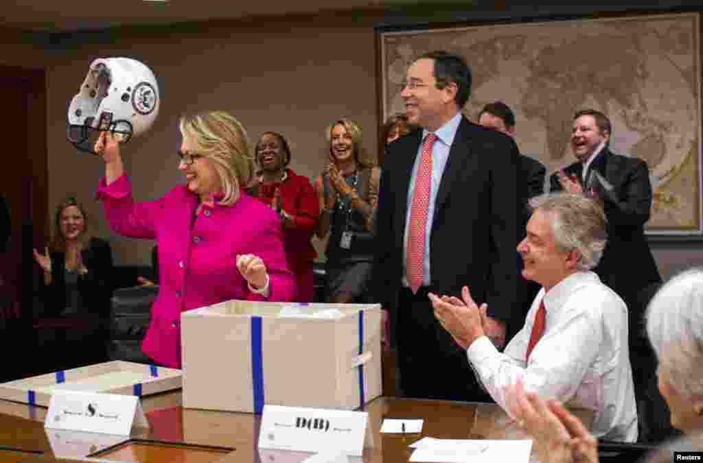 Ngoại trưởng Clinton cầm chiếc mũ bóng đá có logo của Bộ Ngoại giao, do Phó Bộ trưởng Thomas Nide tặng, 7-1-13