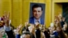 FILE - A supporter holds a portrait of Selahattin Demirtas, detained leader of Turkey's pro-Kurdish opposition Peoples' Democratic Party at a meeting at the Turkish parliament in Ankara.