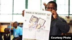 Tshokolo Mokoena, now 51, holds up a newspaper shortly after his release from prison after 19 years for a crime he says he did not commit. (Wits Justice Project)