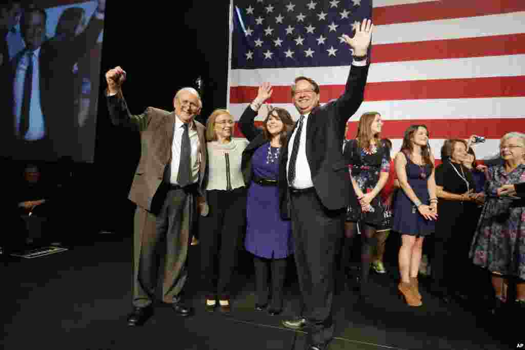 In Michigan, Democratic Senator-elect Gary Peters greets supporters with wife Colleen, in blue. With them in Detroit are retiring Sen. Carl Levin, his wife Barbara Halpern-Levin and, at far right, U.S. Senator Debbie Stabenow, Nov. 4, 2014.