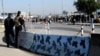 Iraqi security forces stand guard at the site of a bomb attack in Baghdad, Iraq, Jan. 12, 2014. 