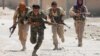 FILE - Kurdish fighters from the People's Protection Units (YPG) run across a street in Raqqa, Syria, July 3, 2017. 